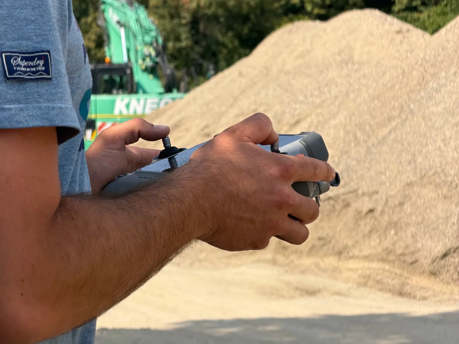 Drohnen-Controller während des Fluges über Schüttgut-Haufwerke im Tiefbau