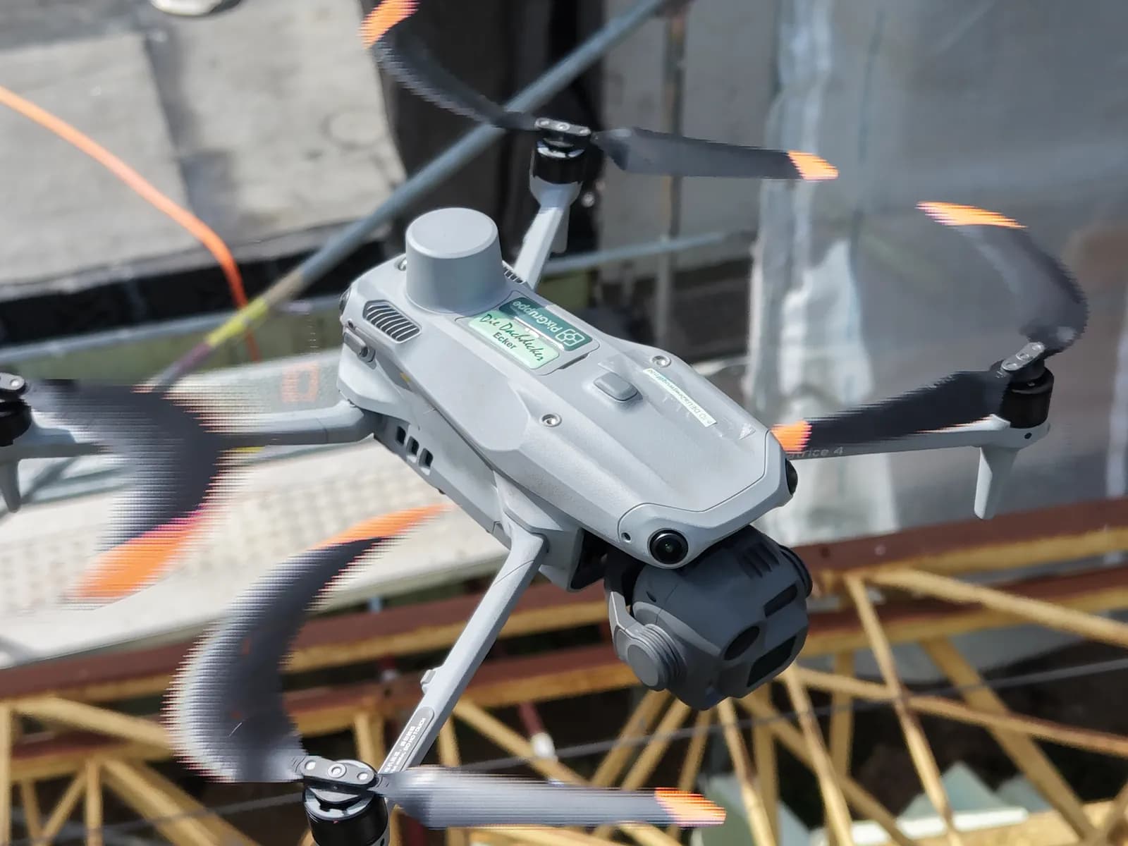 Vermessungsdrohne DJI Matrice 4 der PixGruppe schwebt mit RTK-Modul über einer eingerüsteten Baustelle — Drohnenvermessung für das 3D-Aufmaß